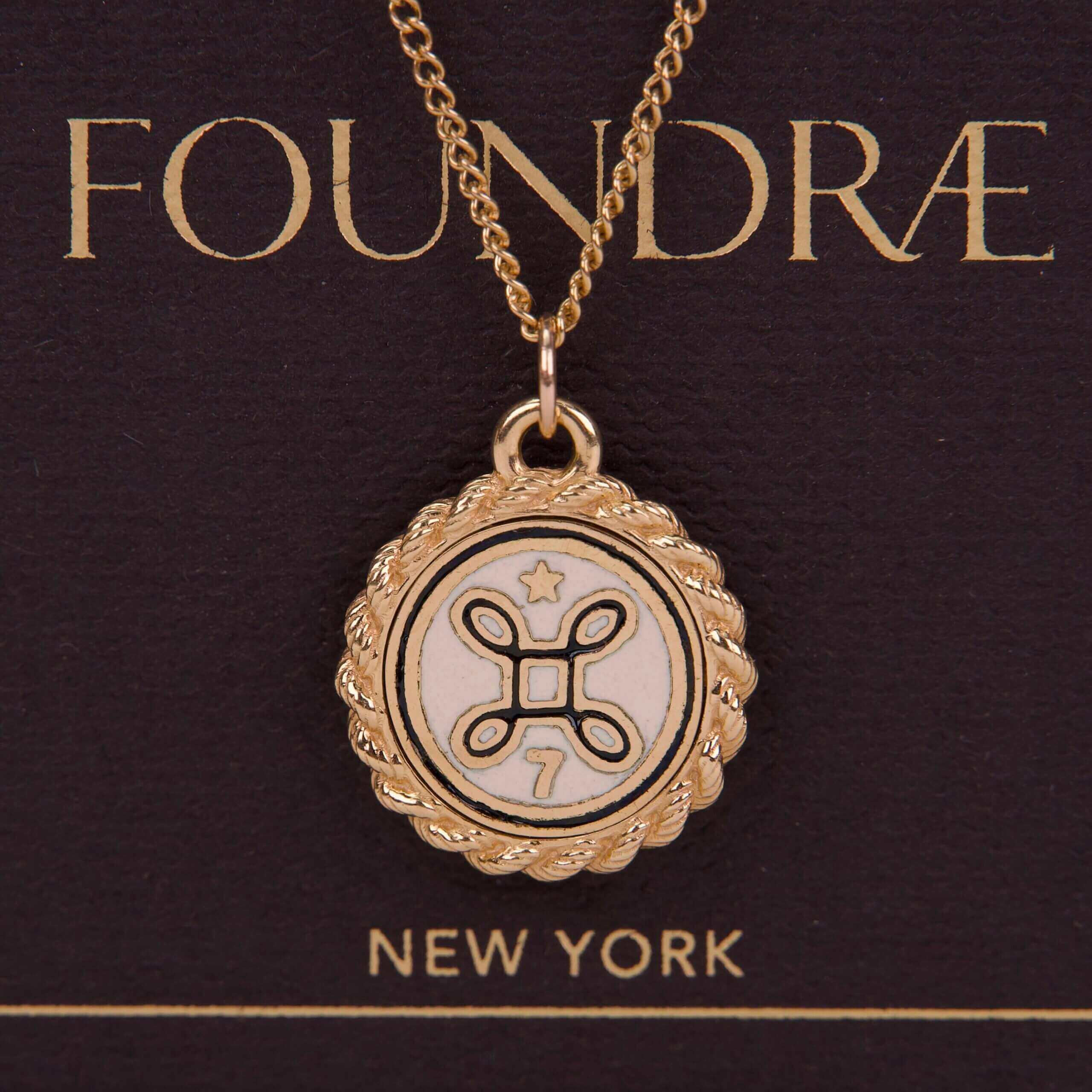 Gold pendant necklace with decorative emblem.