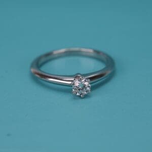 Diamond ring on turquoise background.