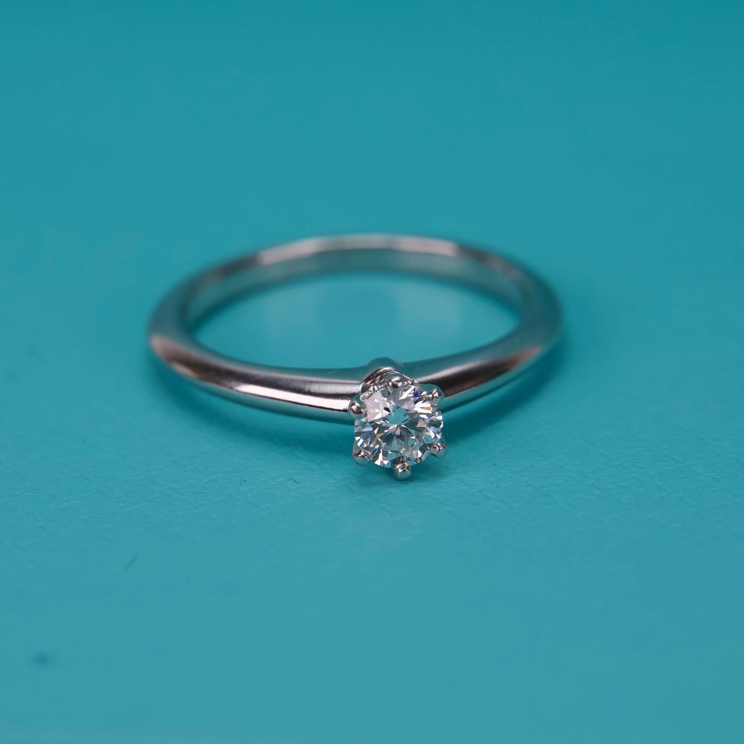 Diamond ring on turquoise background.
