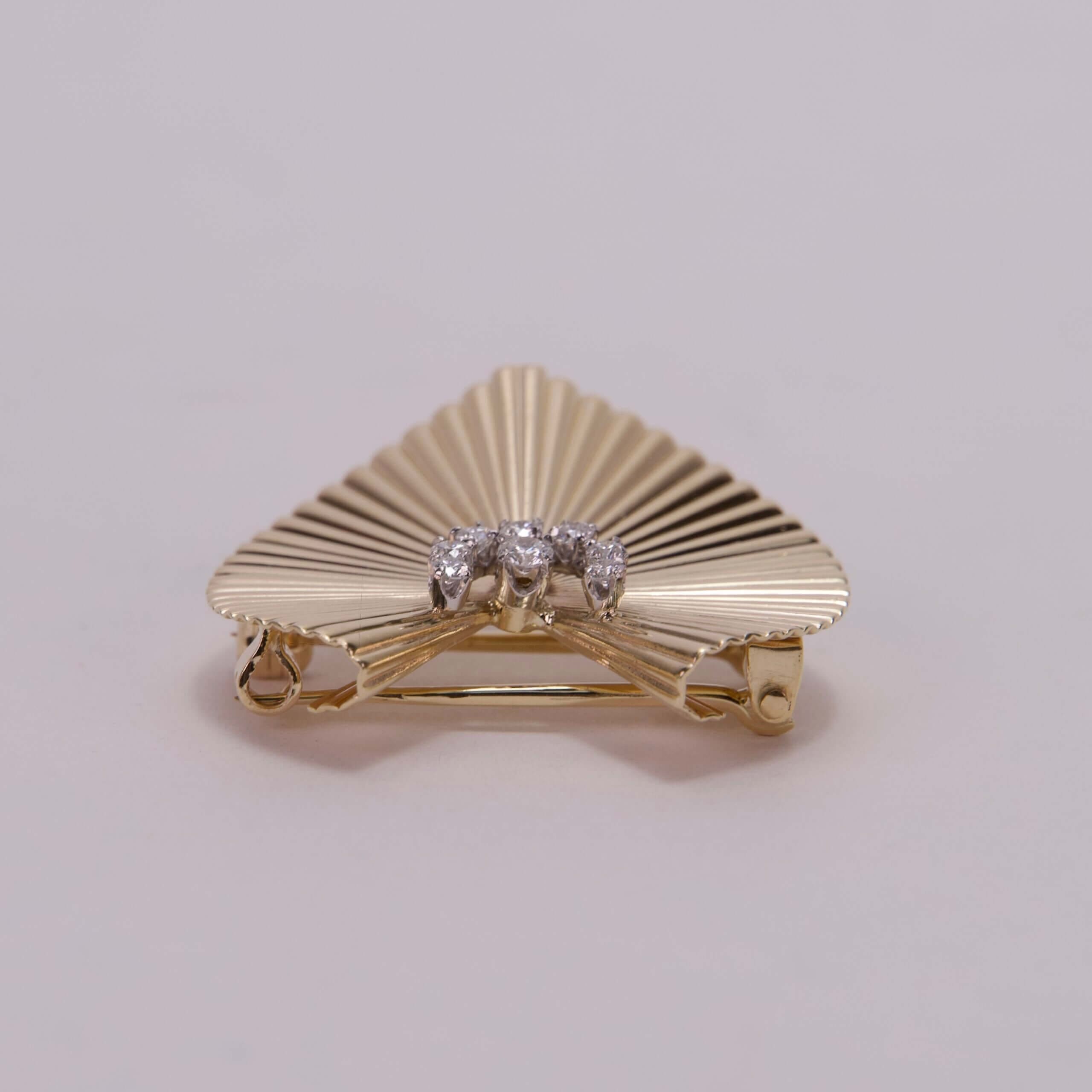 Gold fan-shaped brooch with diamonds.