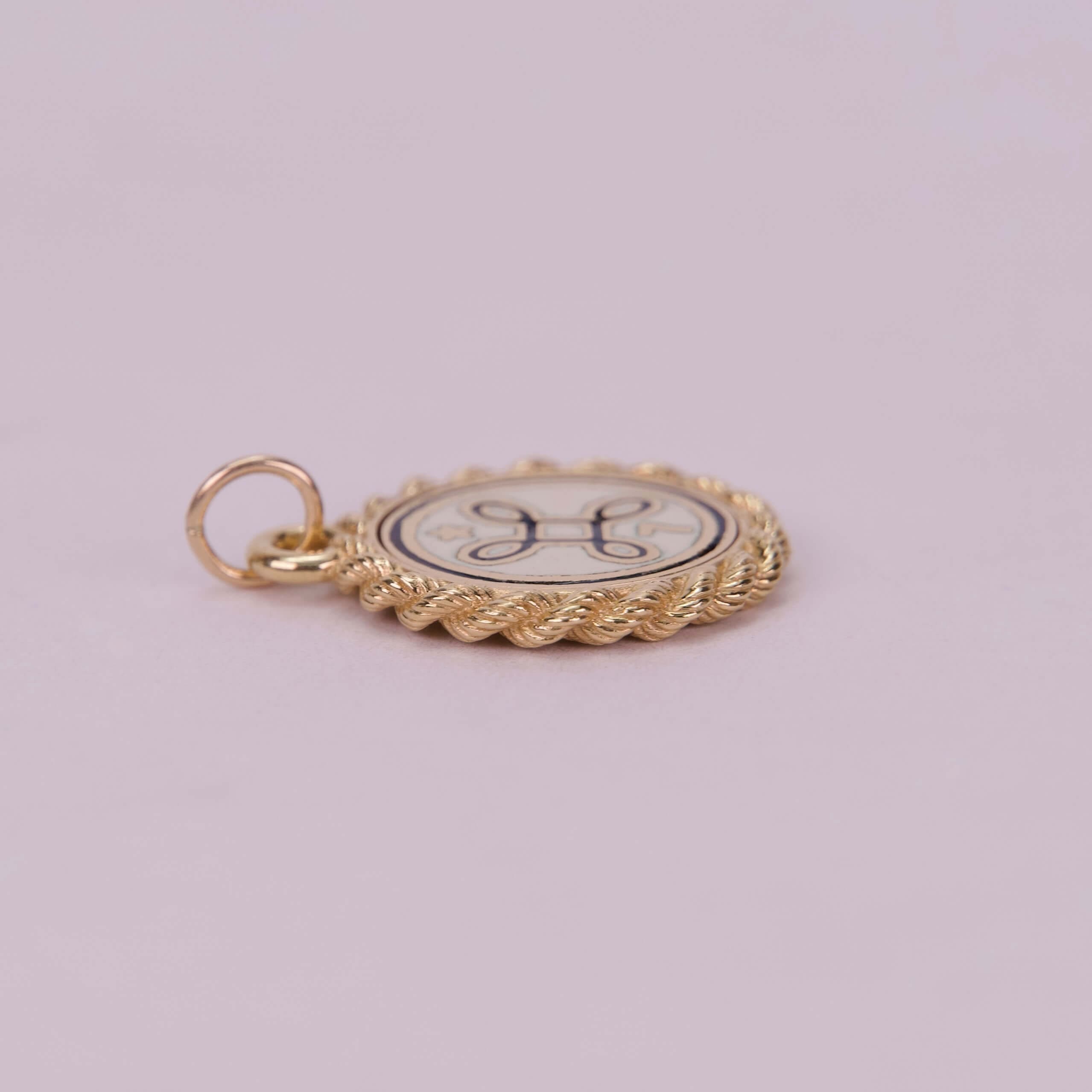 Gold circular pendant with decorative design.