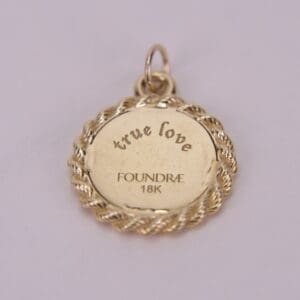 Gold pendant with "true love" engraving.