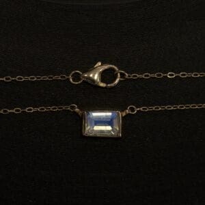 Gold chain with clasp and gemstone pendant.