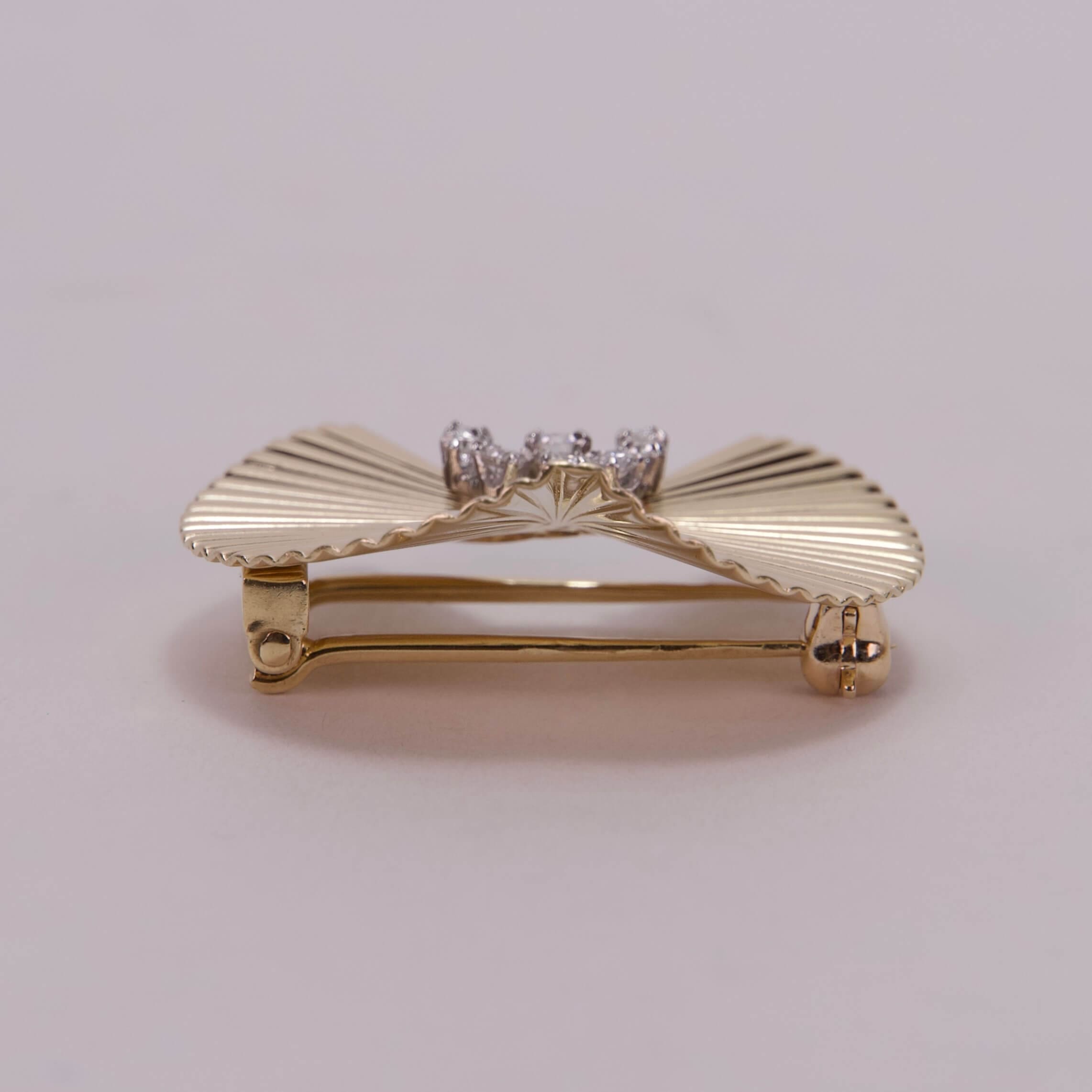 Gold bow-shaped brooch with diamonds.