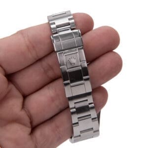 Hand holding a stainless steel watch bracelet.