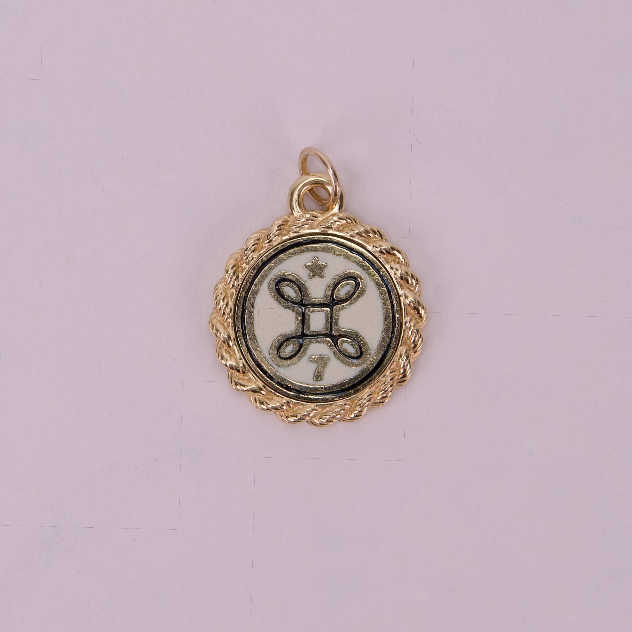 Gold pendant with intricate circular design.