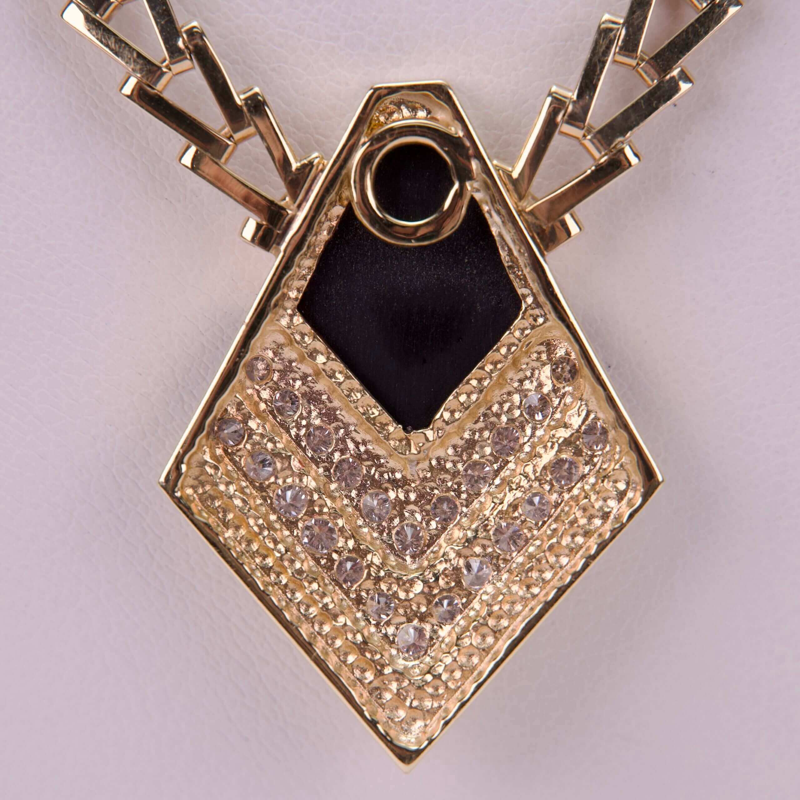 Gold pendant with geometric design and gemstones.