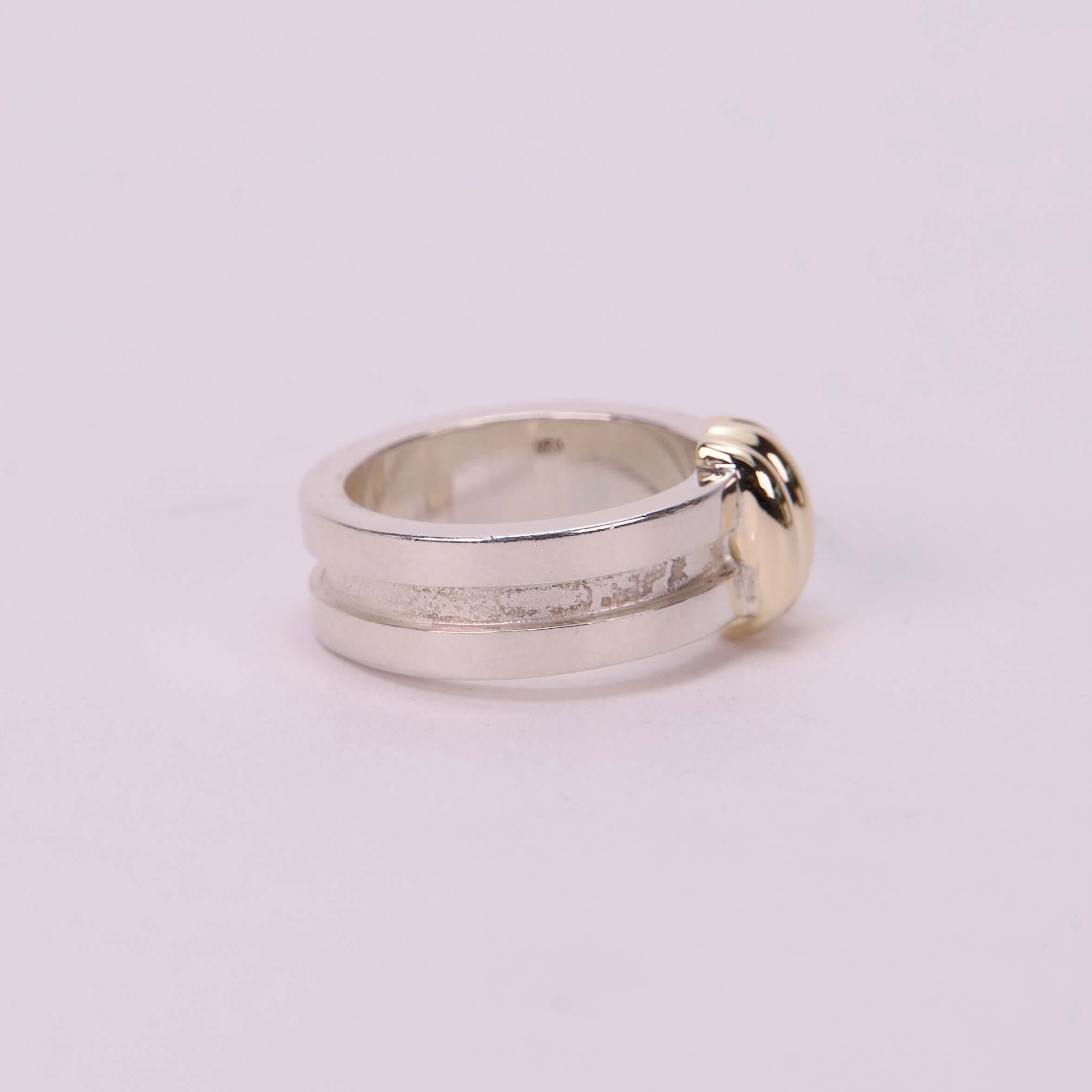 Silver ring with gold accent detail.