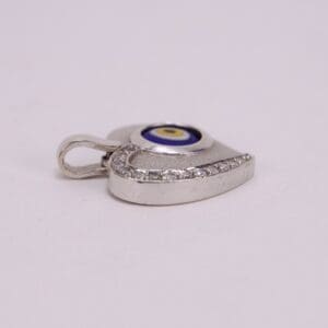 Silver eye-shaped pendant with rhinestones.