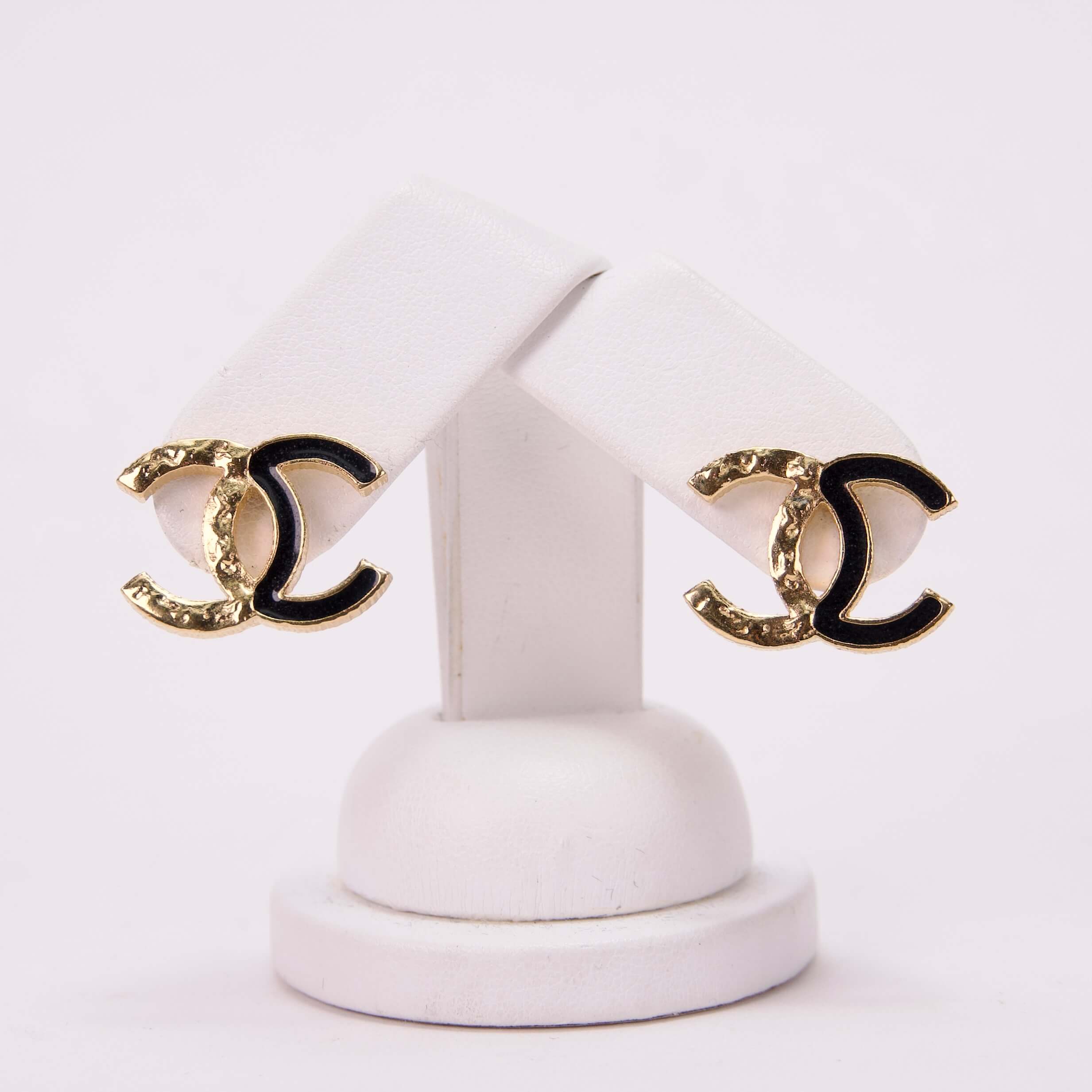 Gold and black designer logo earrings.