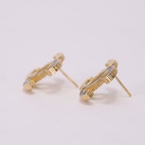 Gold stud earrings with textured design.