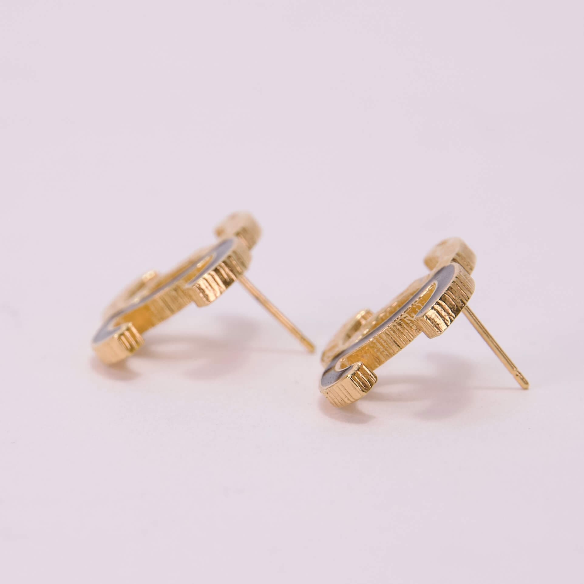 Gold stud earrings with textured design.