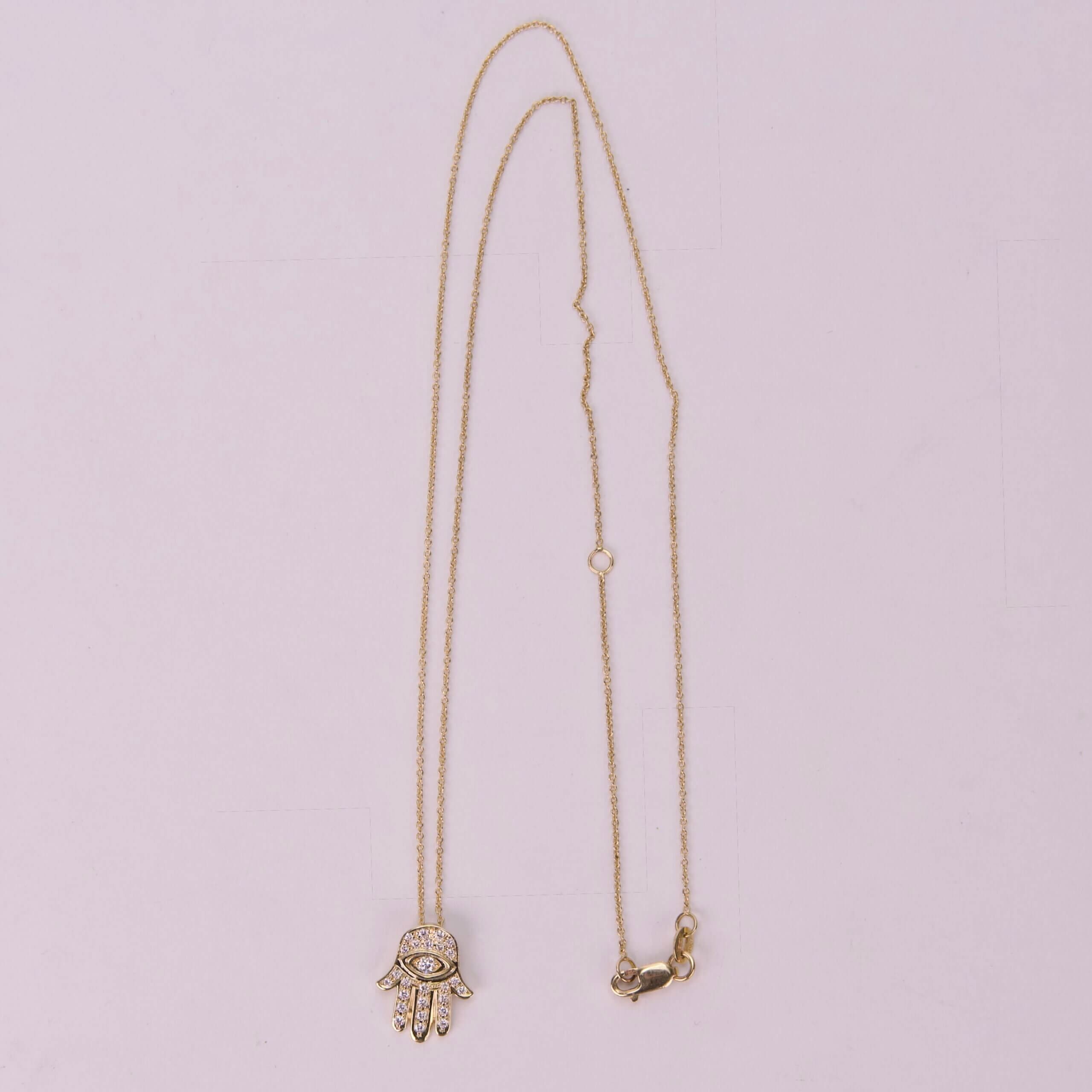 Gold necklace with Hamsa hand pendant.