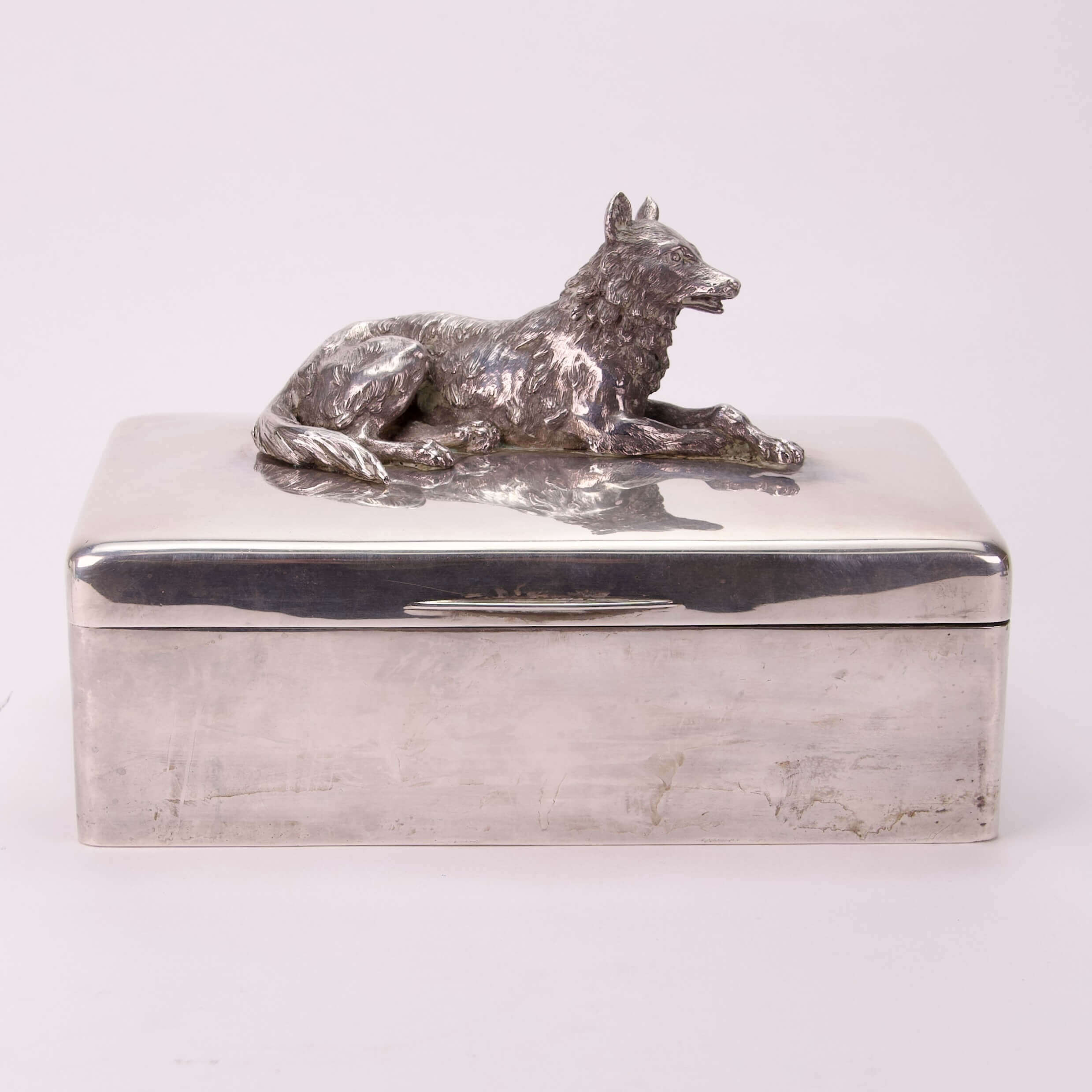 Silver box with a wolf figurine lid.