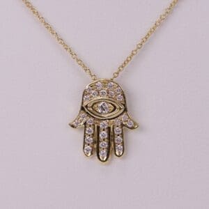 Gold Hamsa pendant with diamond accents.