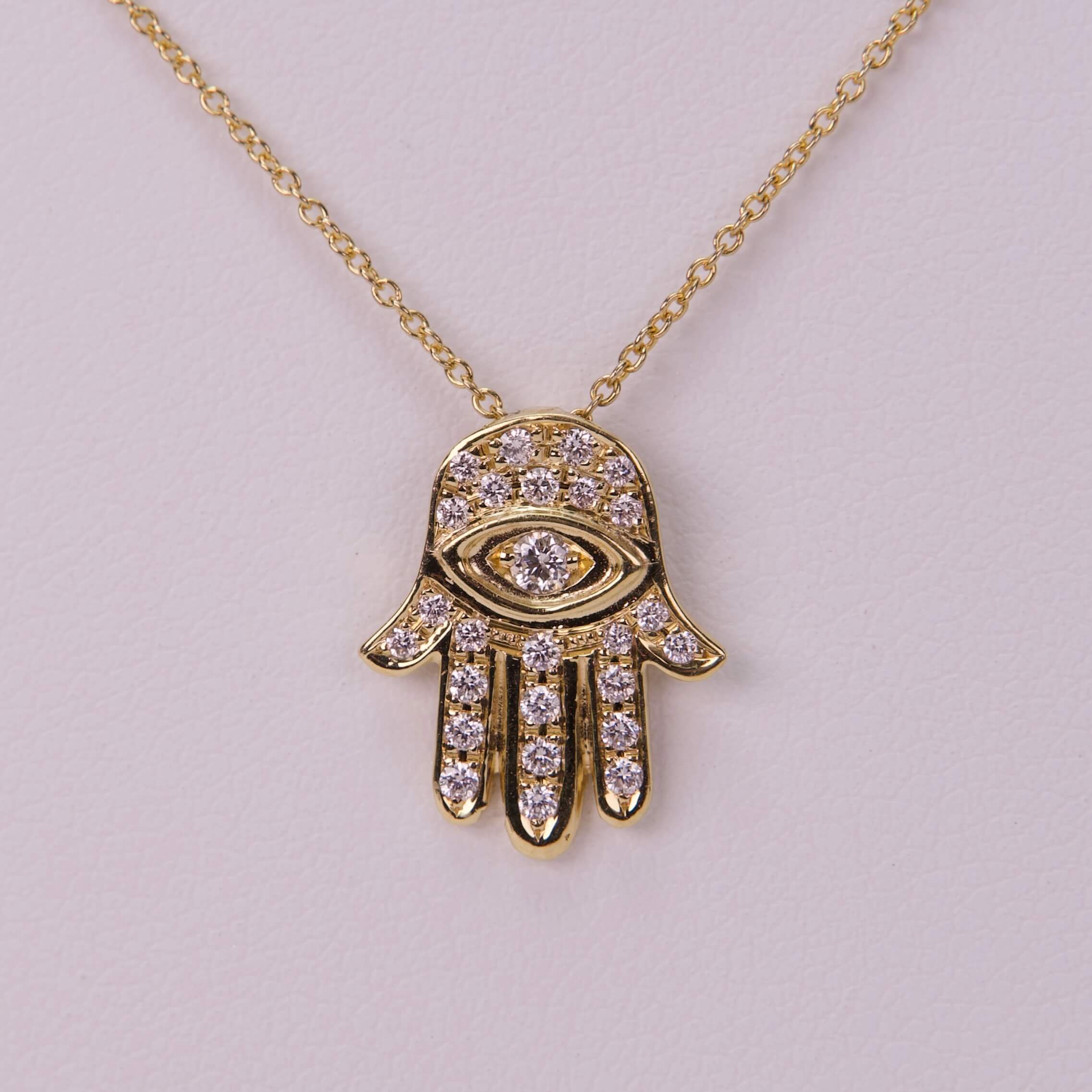 Gold Hamsa pendant with diamond accents.