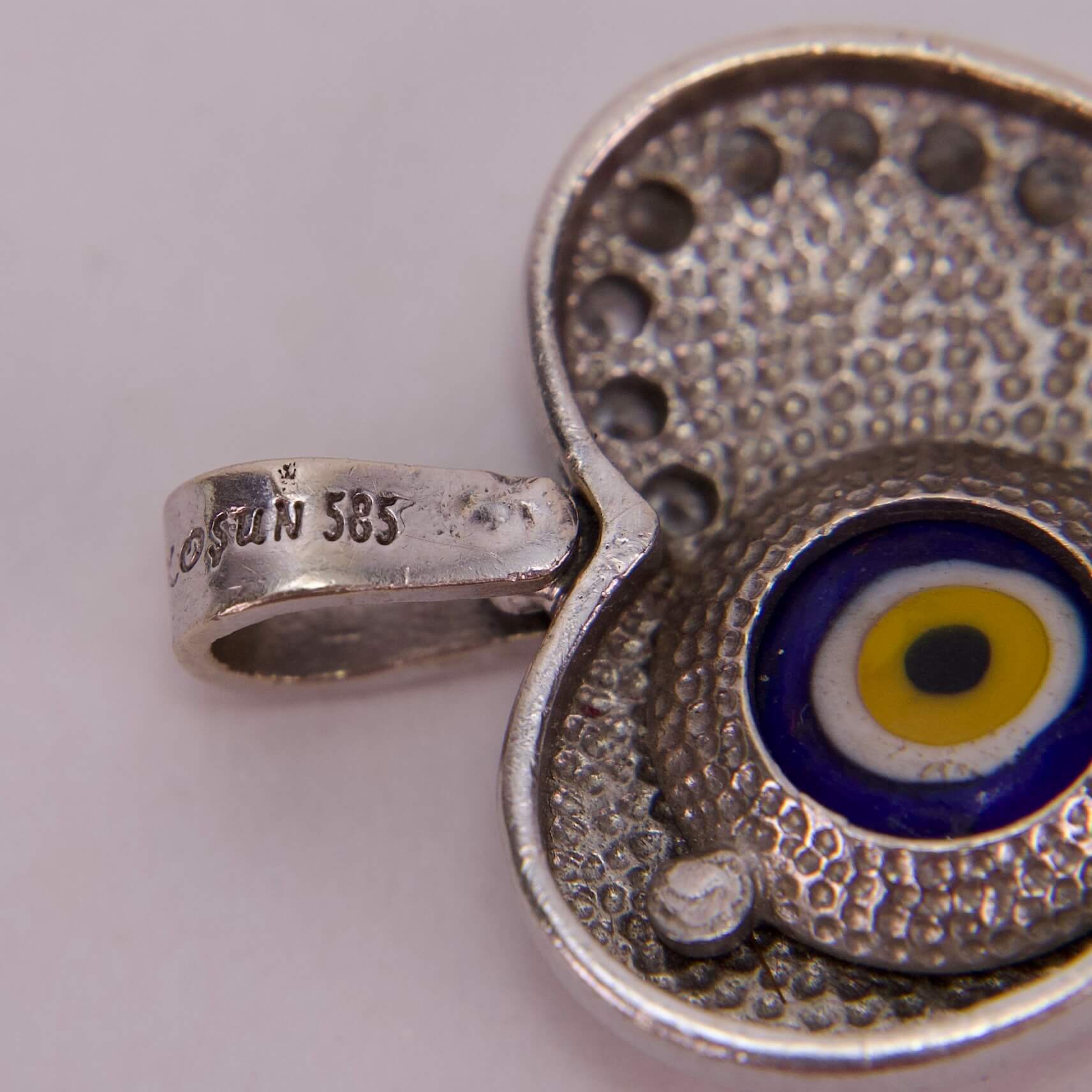 Silver pendant with evil eye design.