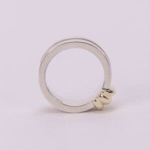 Silver ring with gold knot detail.