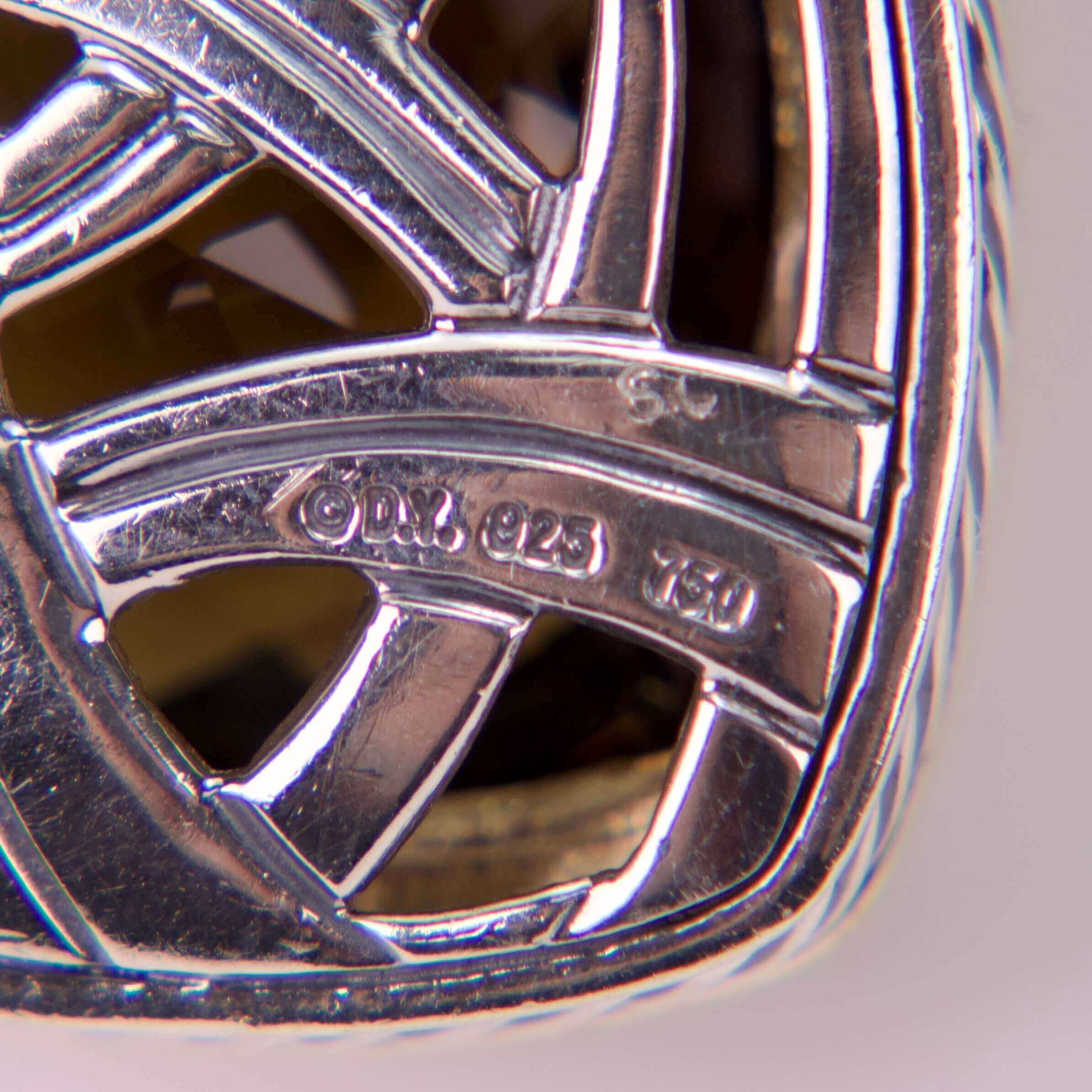 Close-up of silver jewelry hallmarks and lattice.