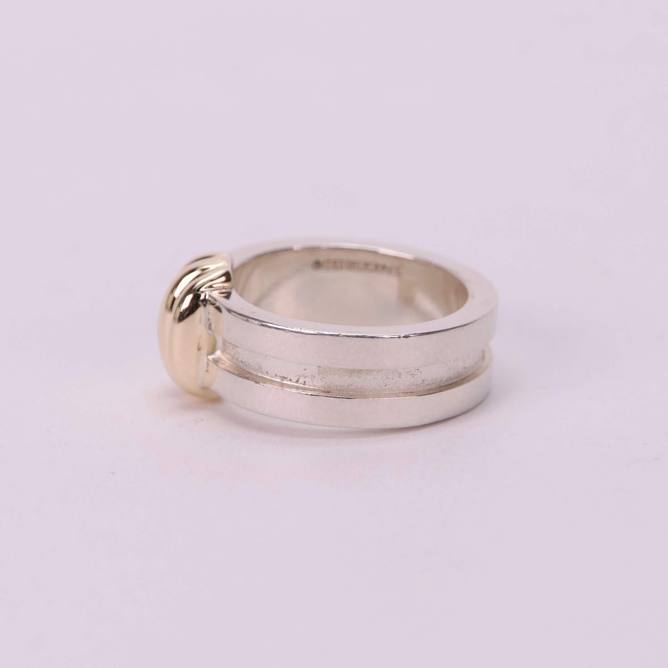 Silver ring with gold accent on side.