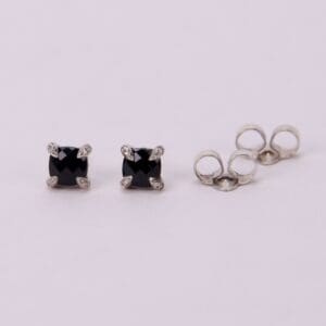 Black stud earrings with silver settings.