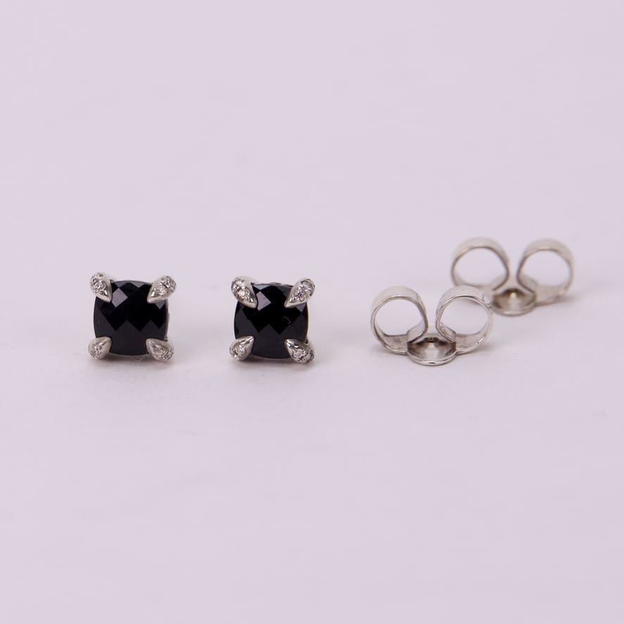 Black stud earrings with silver settings.