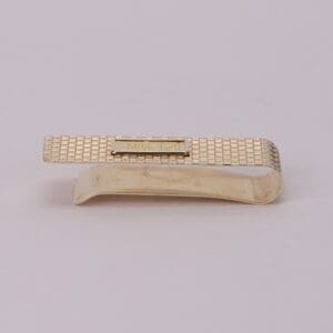 Gold textured money clip on white background.