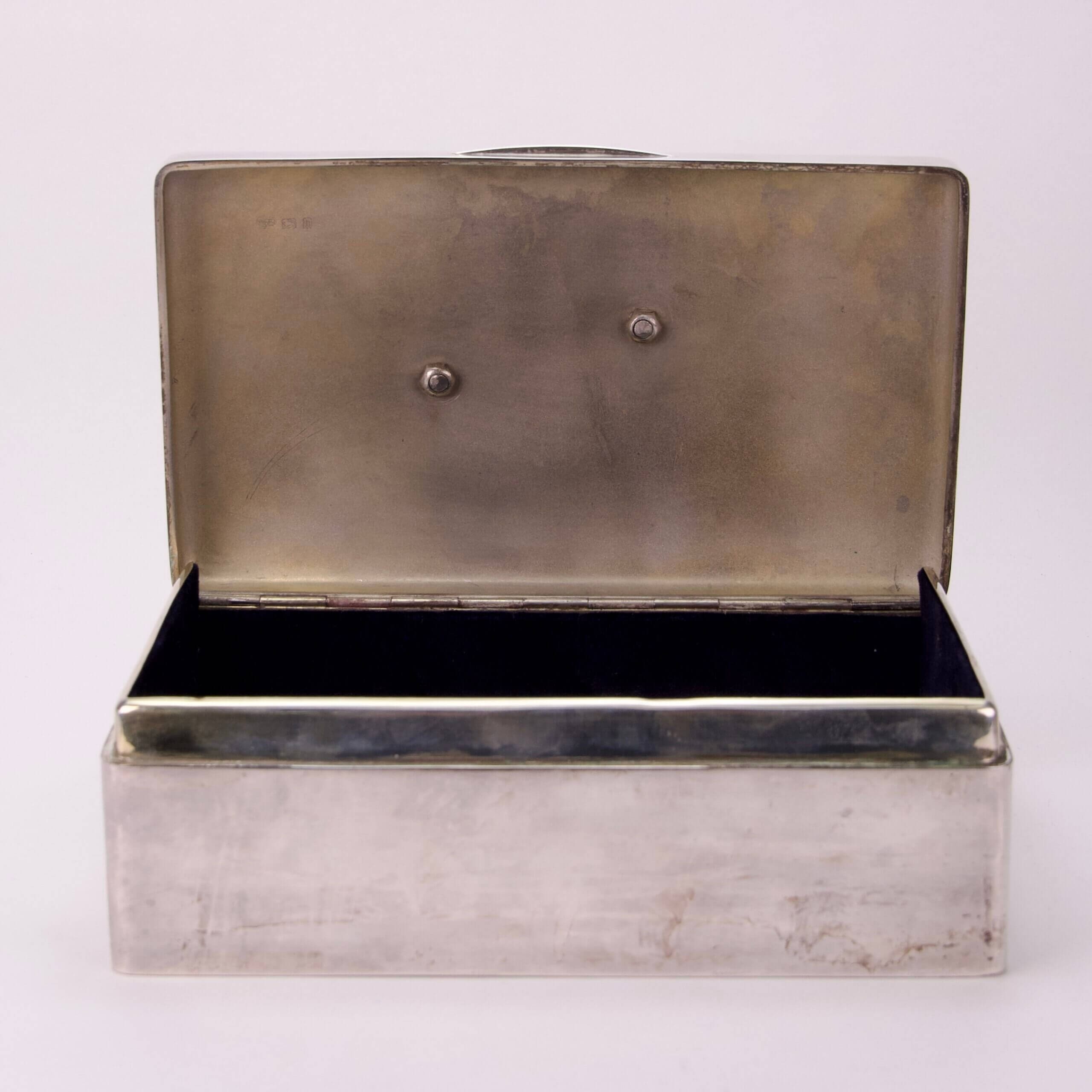 Open silver box with hinged lid.