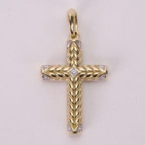 Gold cross pendant with intricate detailing.