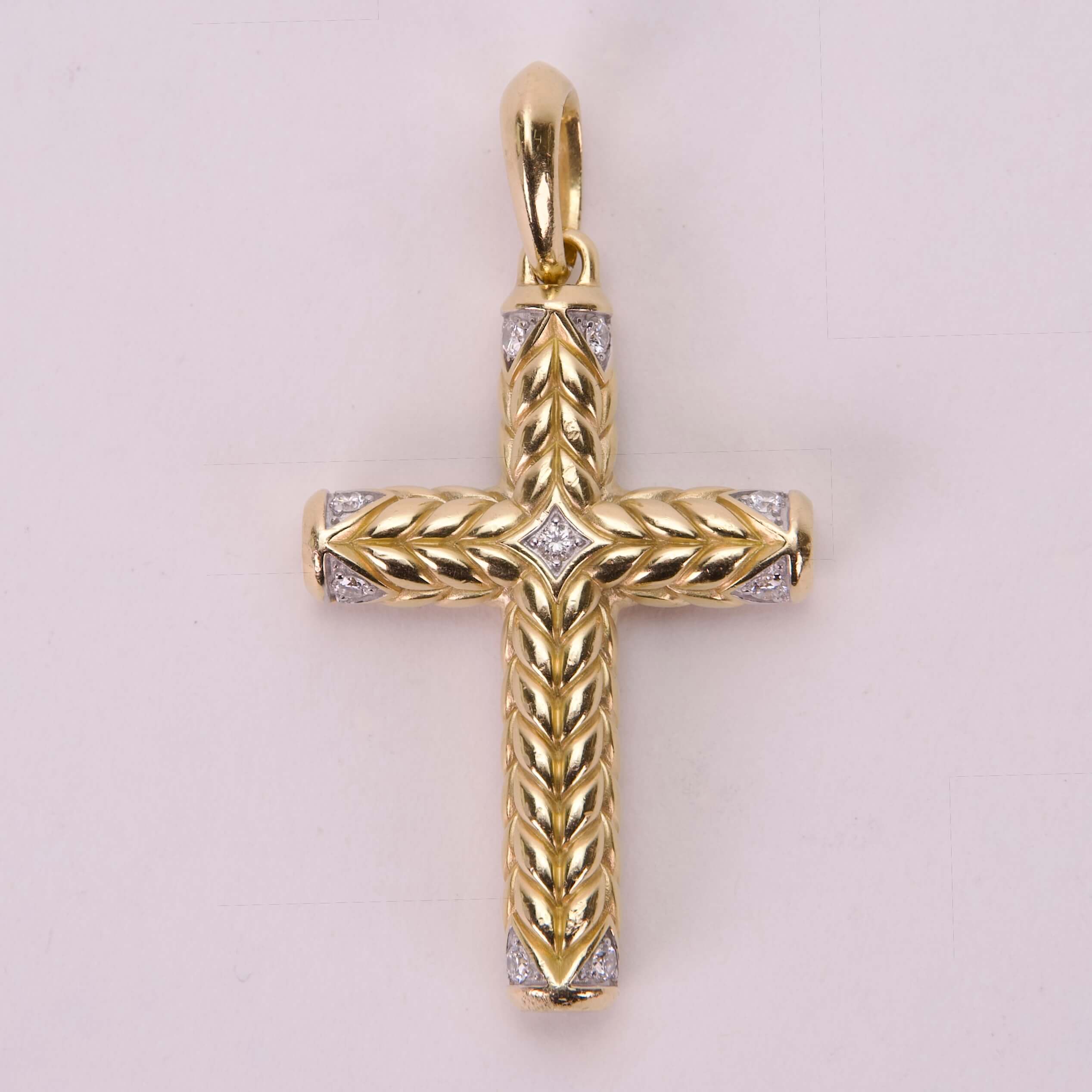 Gold cross pendant with intricate detailing.