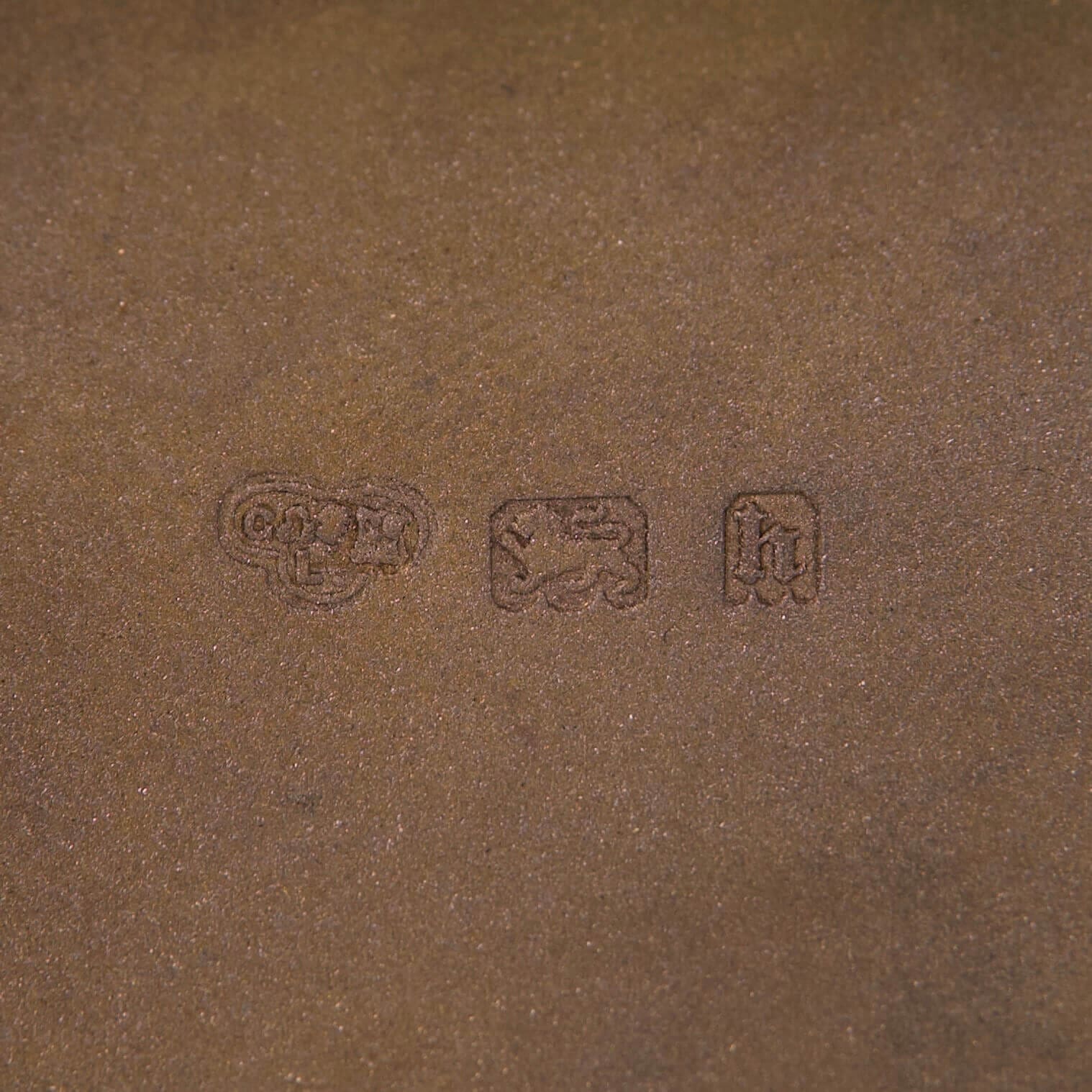 Brown surface with three embossed symbols.