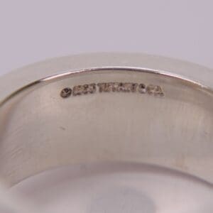Silver ring with engraved text inside.