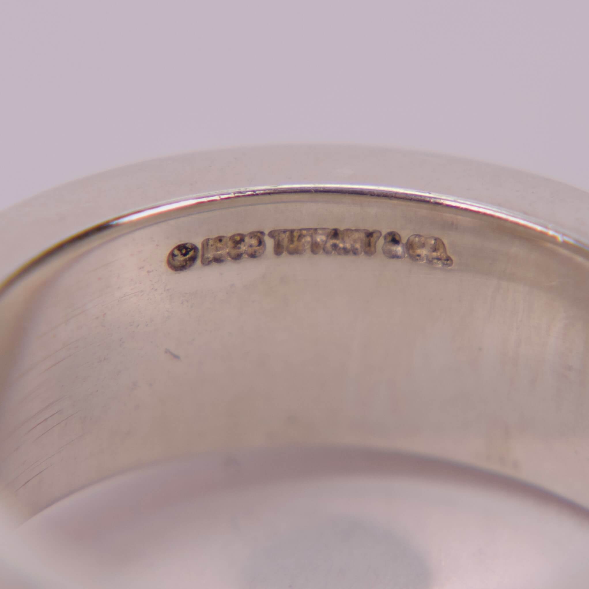 Silver ring with engraved text inside.