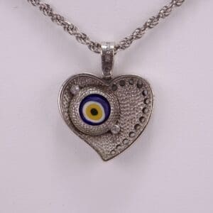 Heart-shaped pendant with evil eye design.
