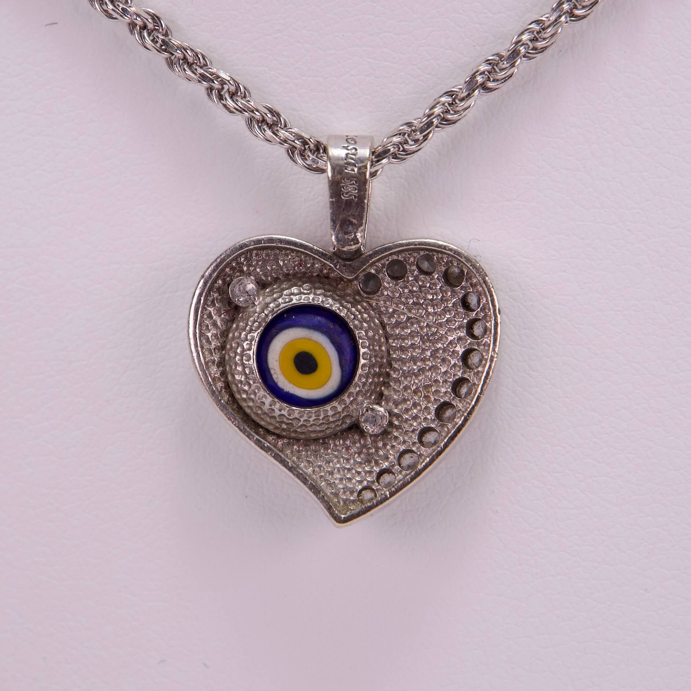 Heart-shaped pendant with evil eye design.