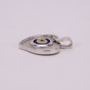 Heart-shaped silver pendant with evil eye.