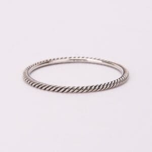 Twisted silver bangle on white background.