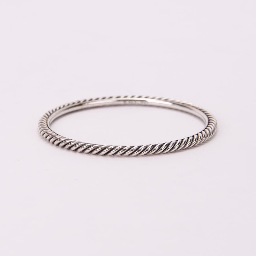 Twisted silver bangle on white background.
