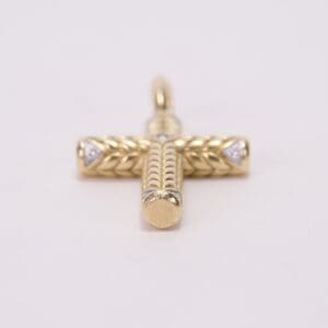 Gold cross pendant with intricate design.