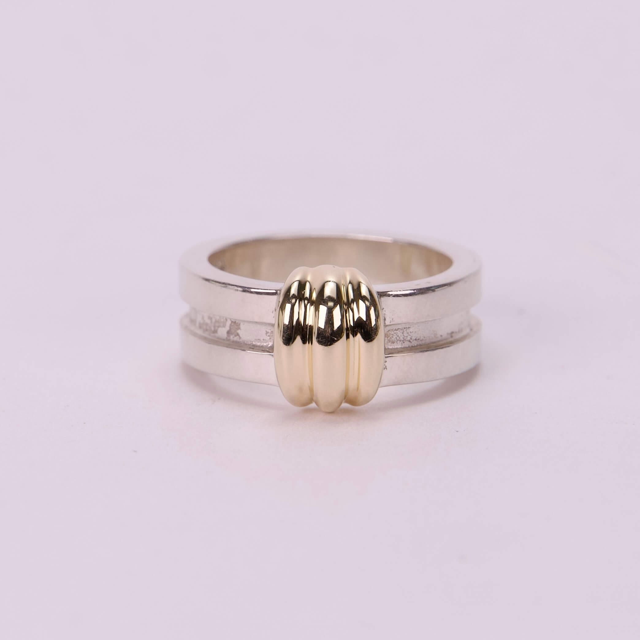 Silver ring with gold accent design.
