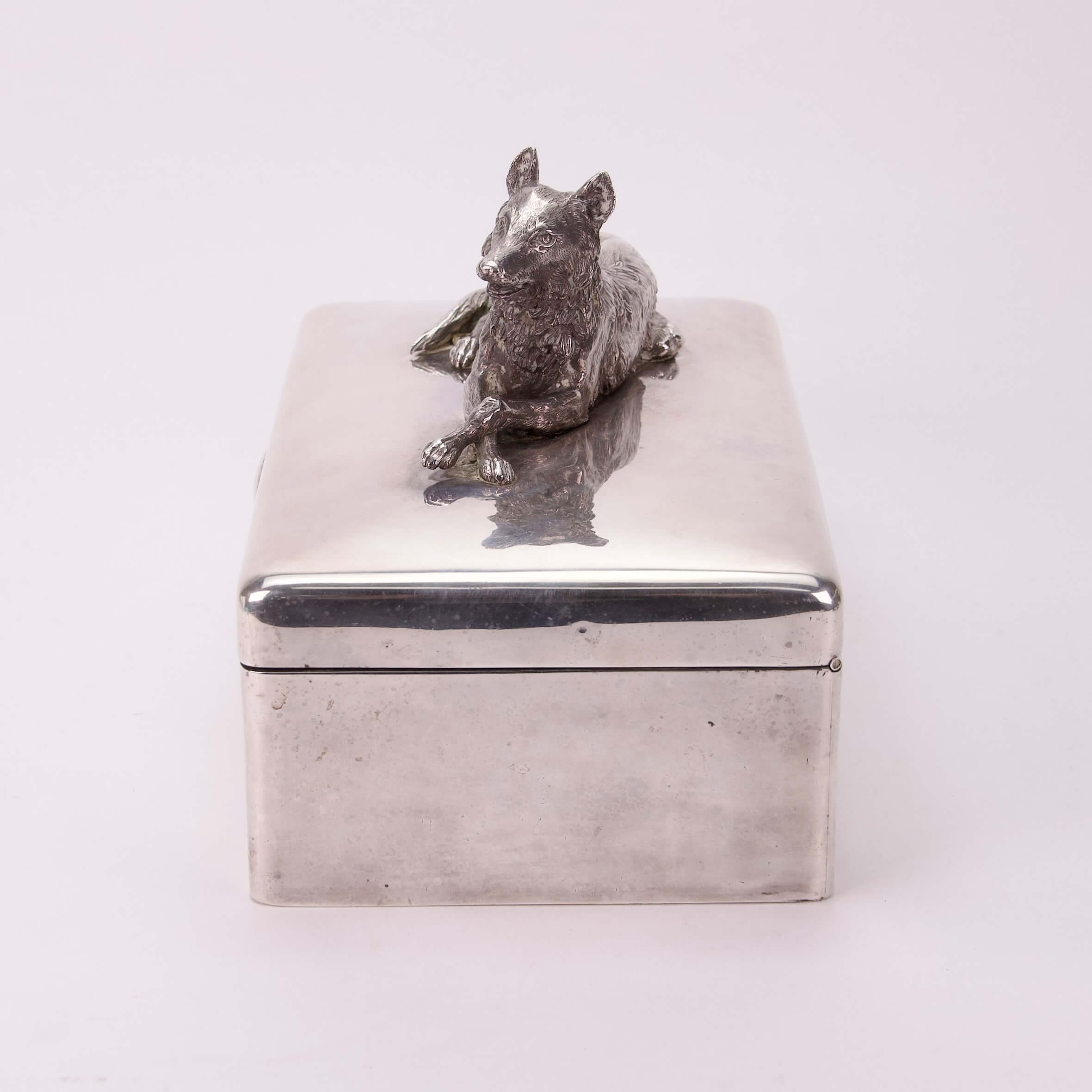 Silver box with wolf figurine on lid.