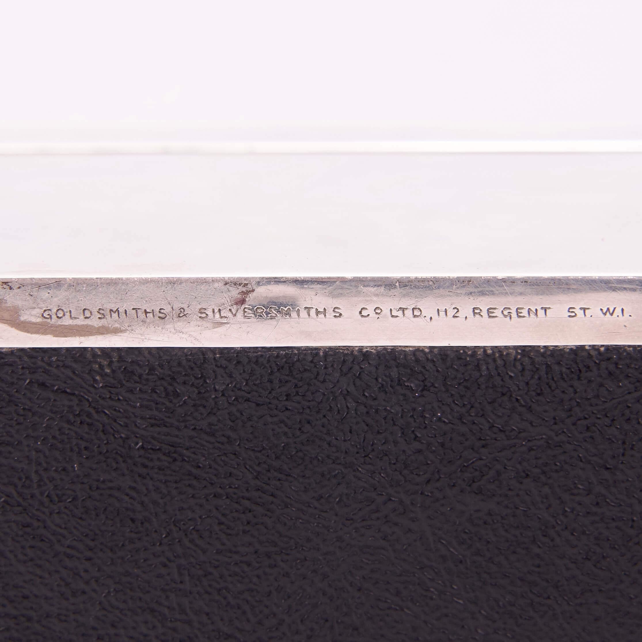 Silver object with engraved text on edge.