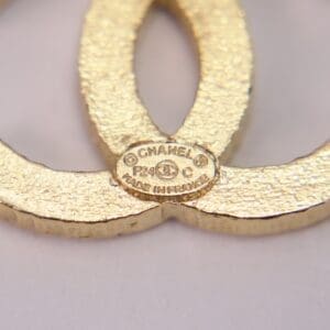 Gold Chanel logo close-up with label.
