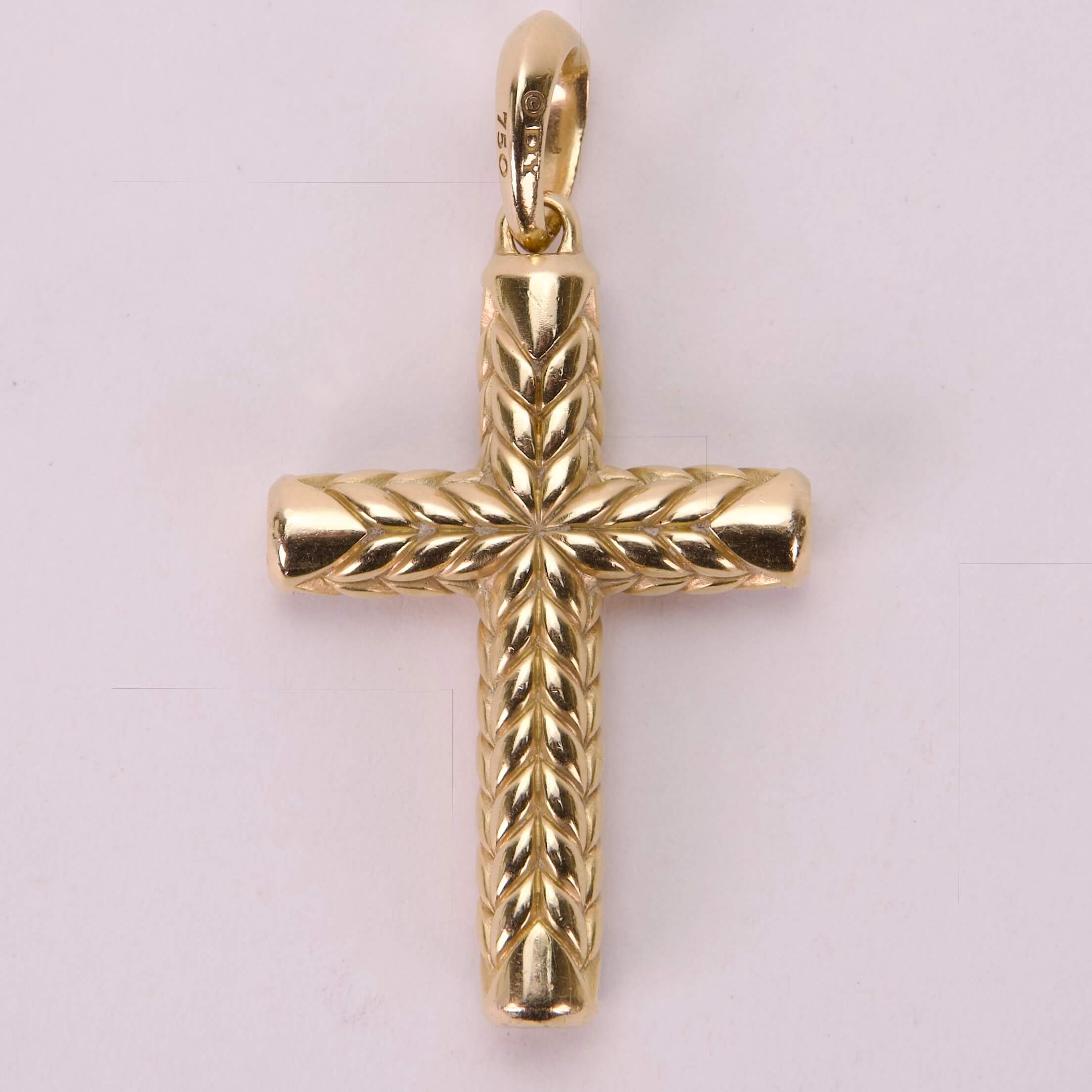 Gold cross pendant with engraved details.