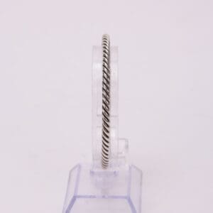 Silver twisted rope design bracelet on stand.