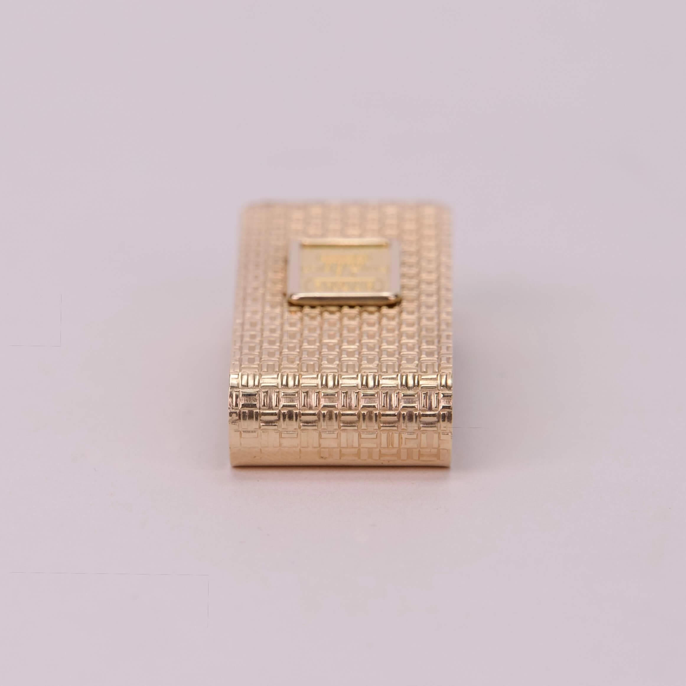 Gold textured rectangular lighter on display.