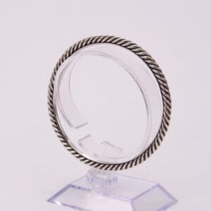Silver twisted rope bangle on display stand.