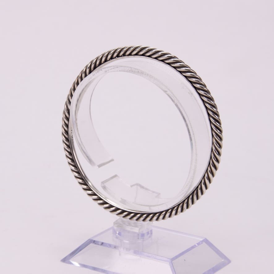 Silver twisted rope bangle on display stand.