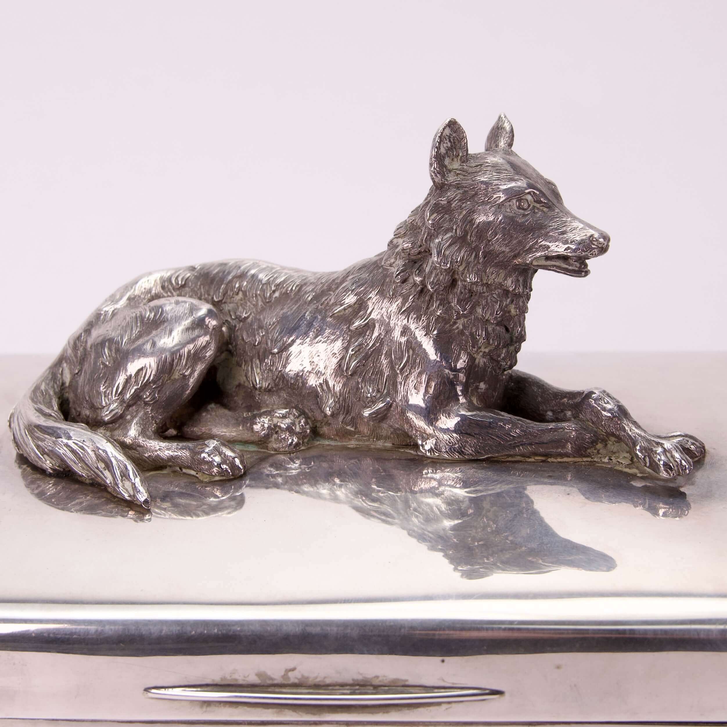 Silver wolf figurine on shiny surface.