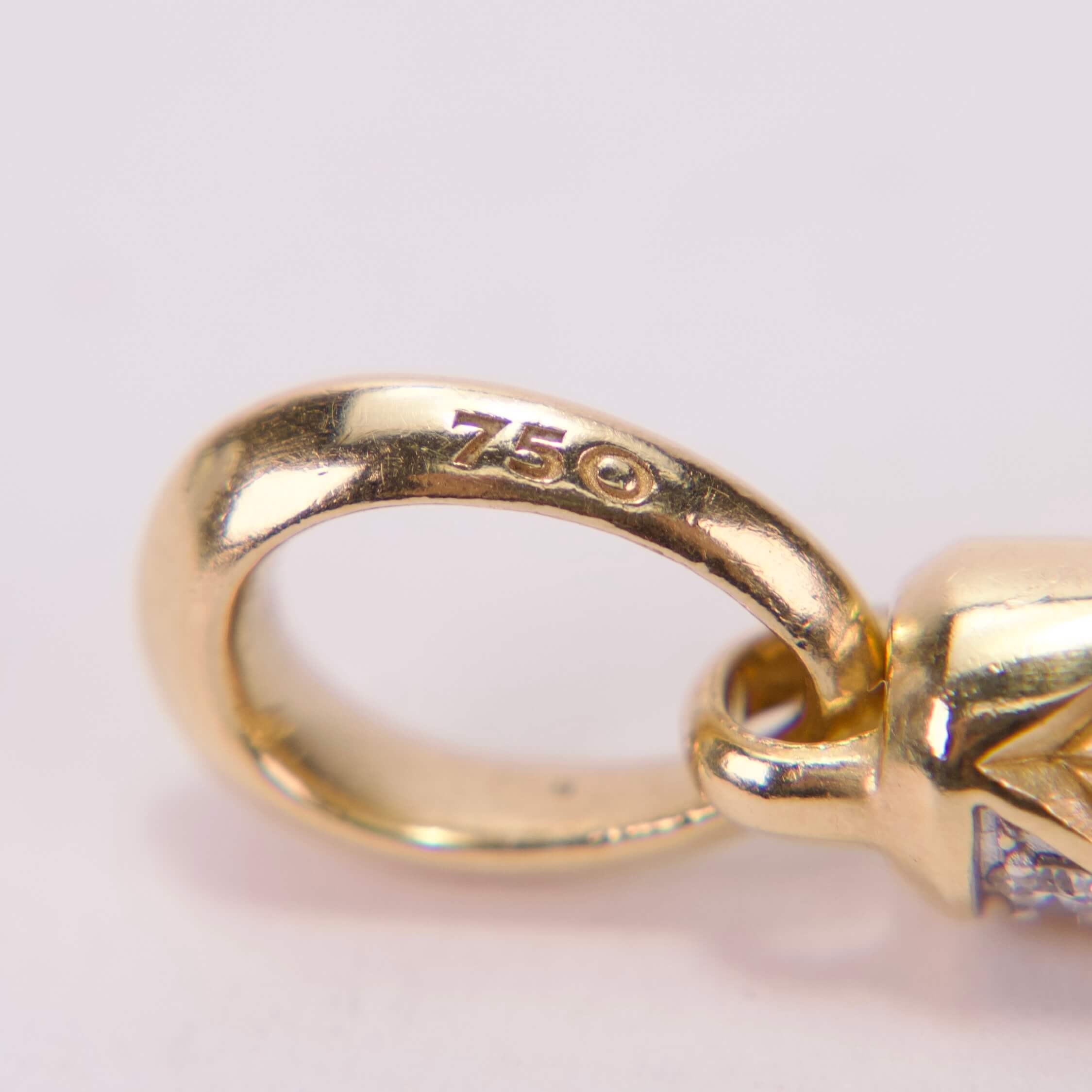 Gold jewelry clasp with "750" marking.